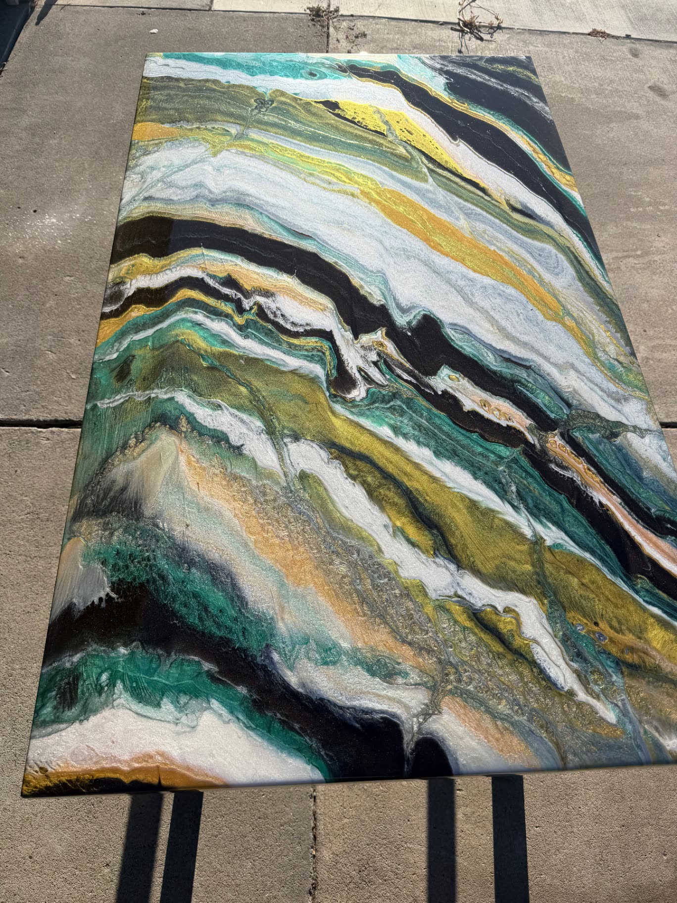 Finished epoxy resin table top with teal, gold, black and white marbled pour