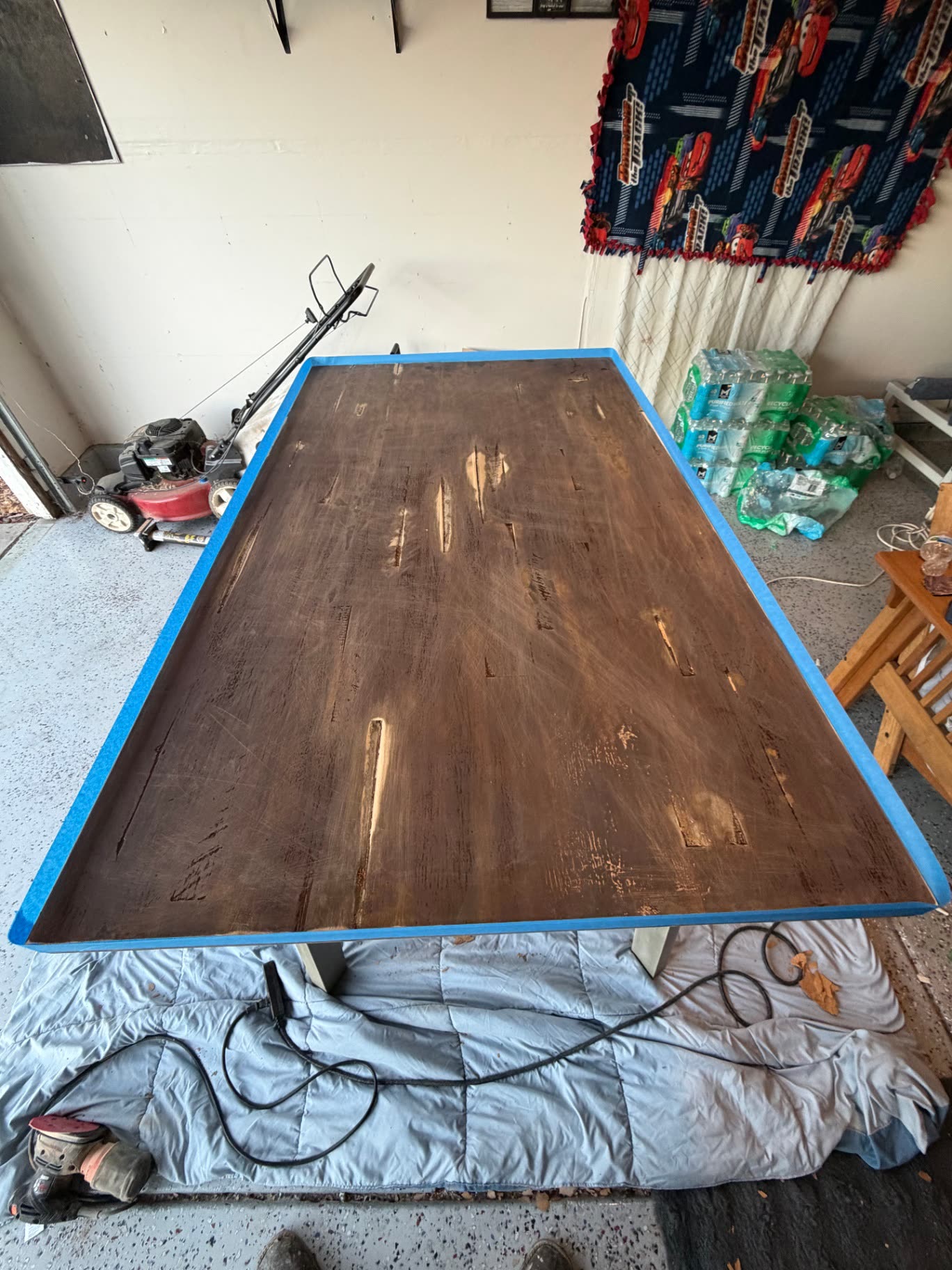 Worn wood table top sanded and taped off before epoxy resin coating