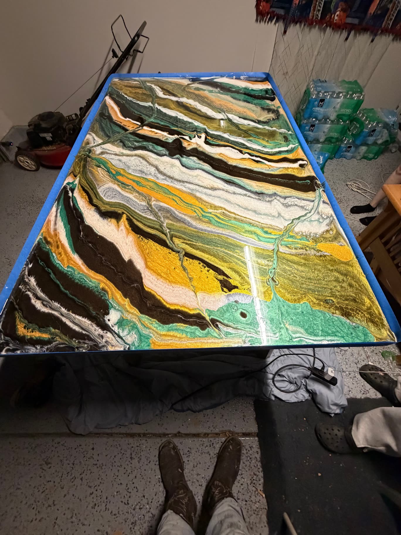 Epoxy resin being poured and marbled across a taped-off table top
