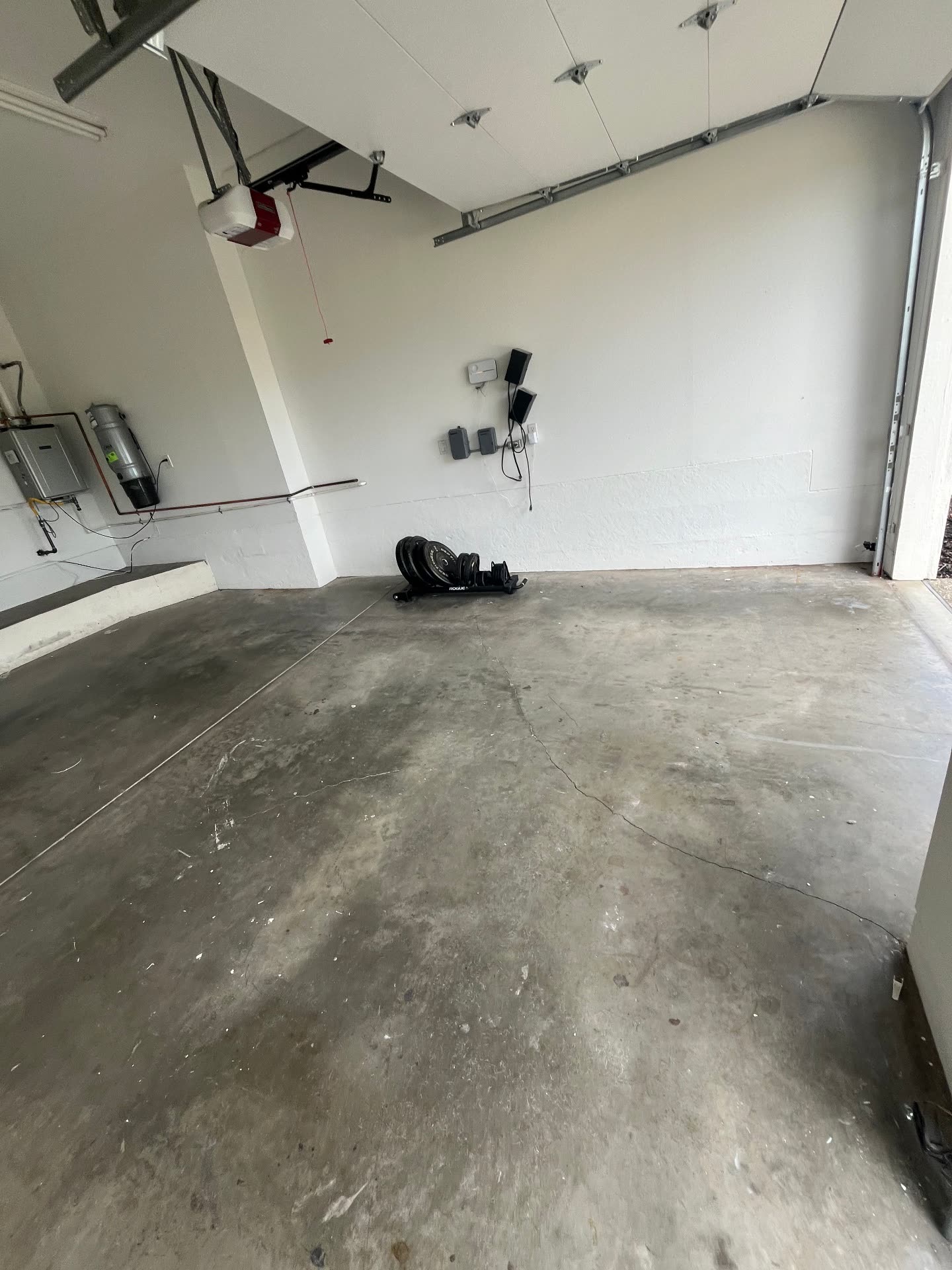 Empty garage bay with cracked concrete floor before epoxy installation