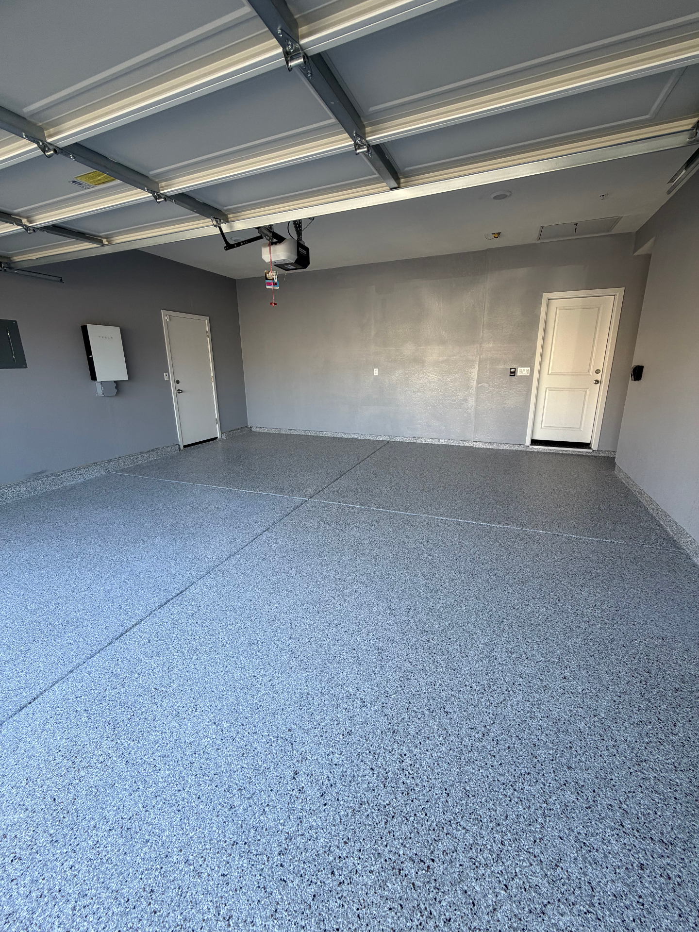 Finished blue and gray flake epoxy garage floor with coved base