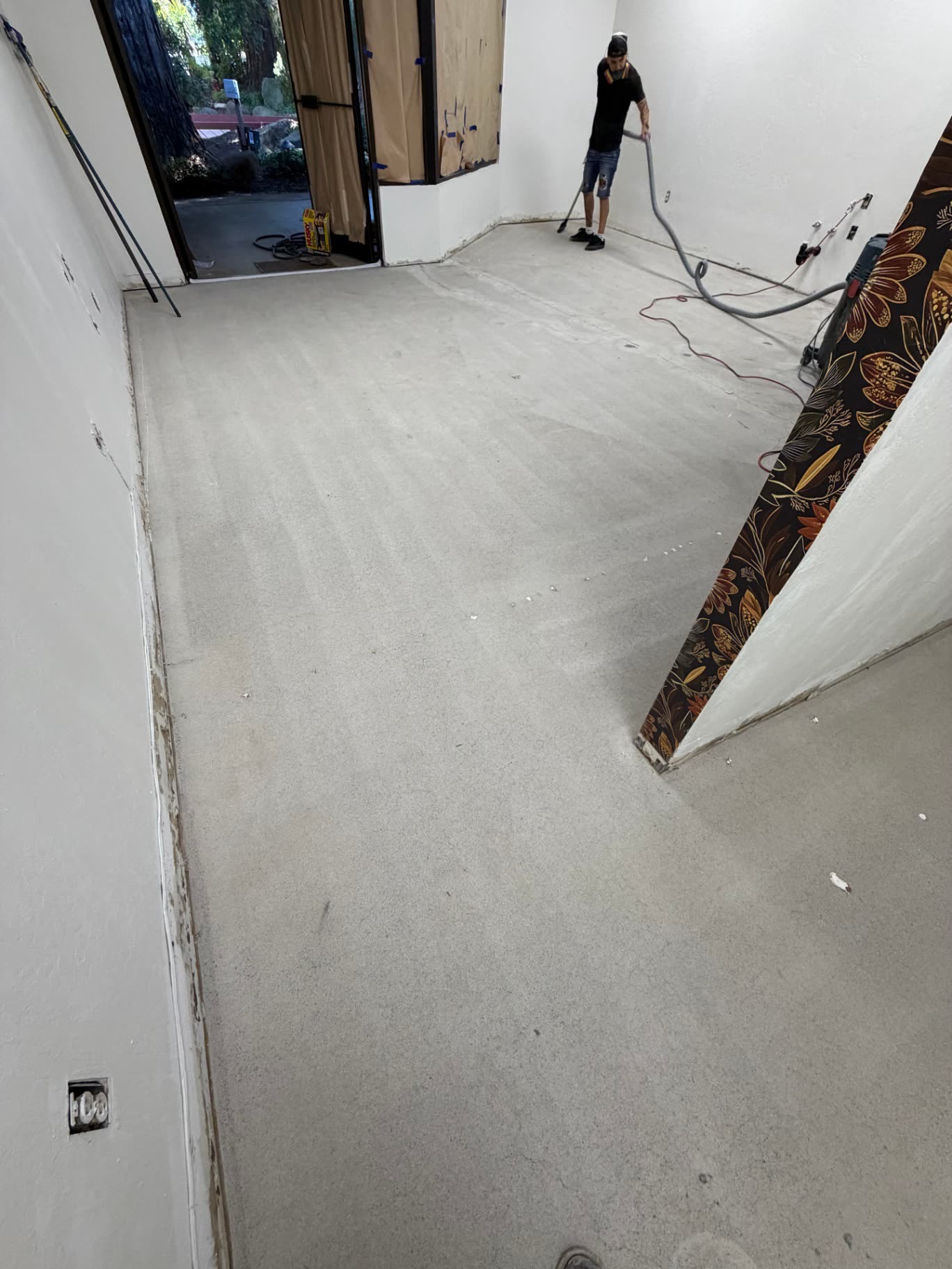 Crew member vacuuming a freshly ground commercial concrete floor